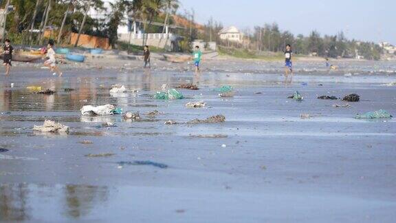 在被垃圾污染的海滩上玩的孩子们的静态镜头