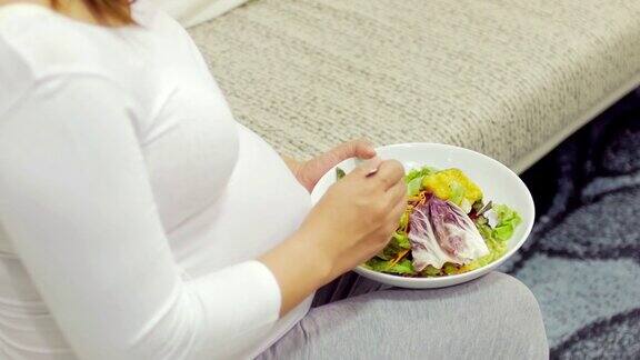 孕妇在家里放松吃沙拉