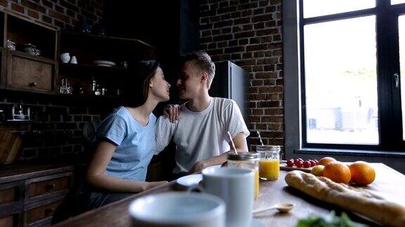 幸福年轻美丽的夫妇在厨房接吻