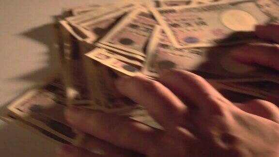 双手从屏幕上抽出桌上的1万日元纸币