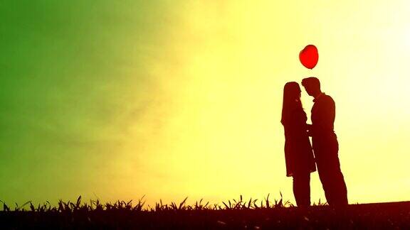 年轻情侣浪漫约会剪影心气球