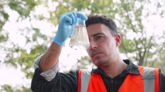 生物工程师在一个试管中检查工厂废水中的污染物