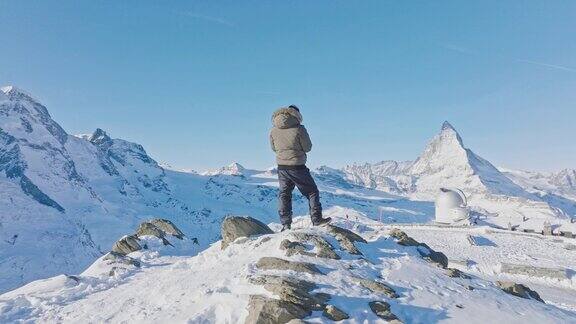 男子操作无人机遥控马特洪峰日落背景瑞士阿尔卑斯山