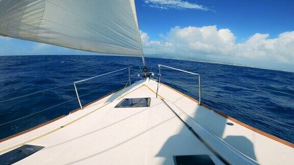 从游艇上的第一人称视角在海上航行在晴朗的日子里帆船在蓝色的海水中航行