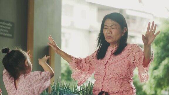 亚洲祖母正用积极的情绪教她的孙女飞行和模仿鸟