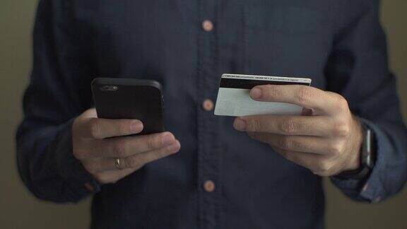 男子插入信用卡号码在手机上网上银行与智能手机