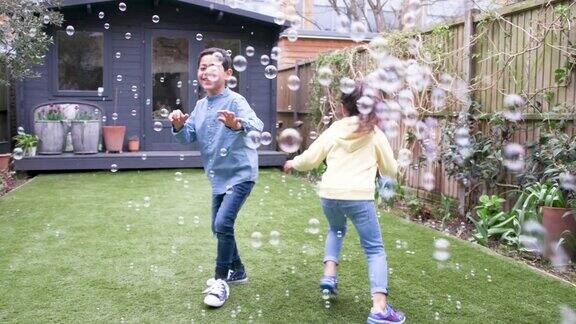 孩子们笑着在花园里追逐着泡沫