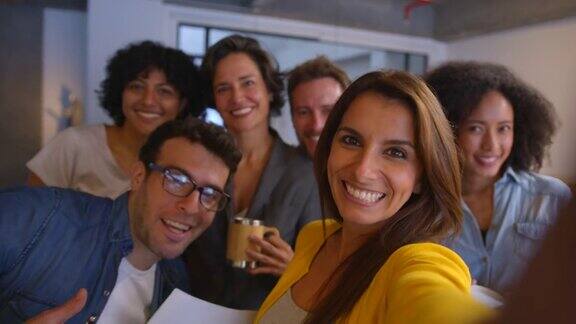 在一家营销公司一群不同的快乐的同事正在休息对着相机微笑着自拍