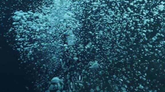 在海洋中带着泡泡的水下潜水员泡泡浮在热带蓝色的海面上