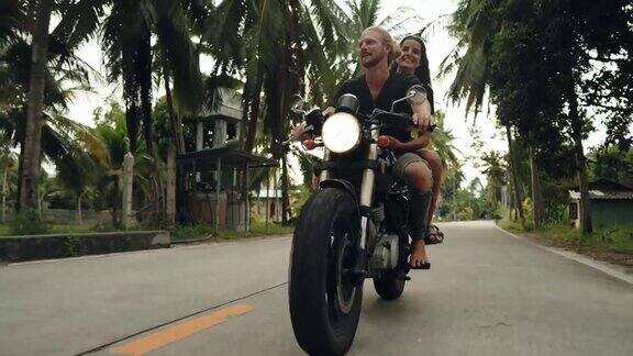 一对夫妇在热带公路上享受骑行