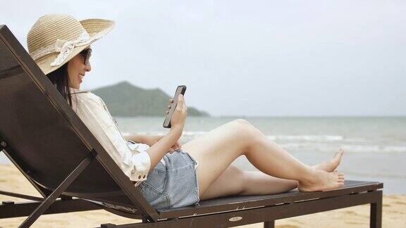 一个女人躺在沙滩上玩手机