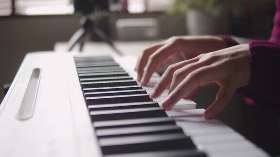 独自在家键盘钢琴爱好年轻女子用智能手机练习钢琴