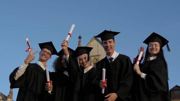 终于自由了毕业后一群兴高采烈的学生身穿毕业服头戴学士帽手握毕业证书站在一起
