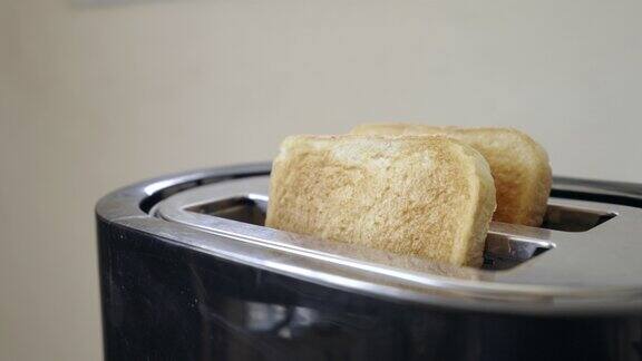 把面包放在厨房里的烤面包机里