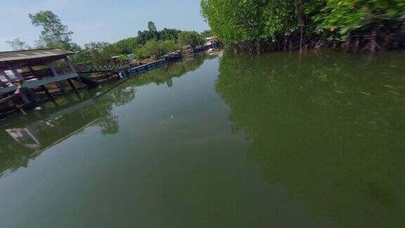 顶视图绿色热带平静河流飞越亚洲村庄堤岸船