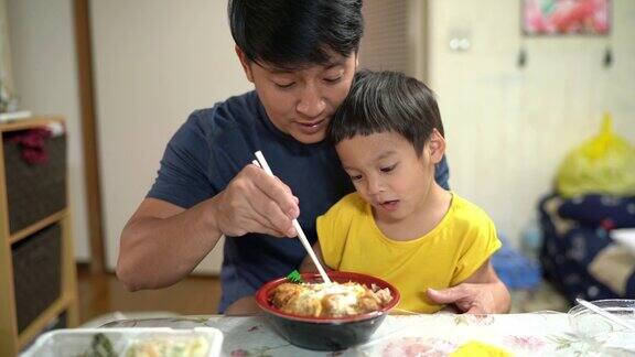 快乐的父子俩小男孩喜欢在家吃日本猪排饭2岁