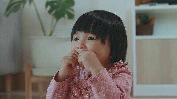 可爱的亚洲幼童小女孩玩和吃零食在家里童年与家庭生活理念