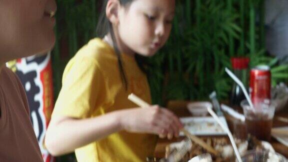 快乐的亚洲儿童在午餐时间一起在餐厅吃日本食物生活理念沙巴鱼配酱汁和饭团