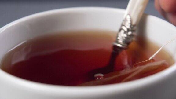 把红茶和茶包放在一个白色的杯子里搅拌