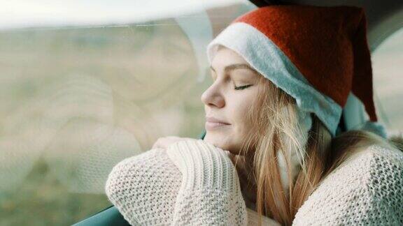 头上戴着圣诞帽的女人睡在汽车后座上
