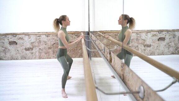 一个芭蕾舞演员在镜子前热身