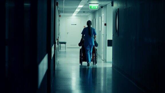 女护士推着轮椅上的病人穿过医院走廊她们正在进行手术明亮的现代医院和友好的员工