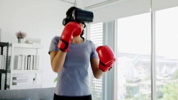 亚洲少女戴着虚拟现实眼镜和拳击手套在客厅里锻炼和玩虚拟游戏现代健身技术视频培训体育