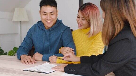 房地产经纪人解释亚洲夫妇关于合同和丈夫在新家签订房屋合同购买新的房地产