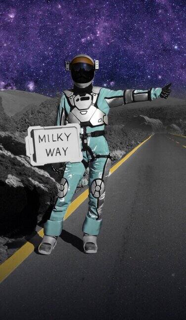 寻求帮助的宇航员在这个多色星球上在一条超现实的山路上搭便车举着“银河”的牌子