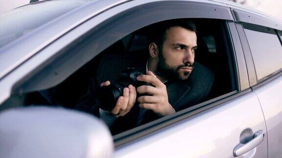年轻私家侦探坐在车里用单反相机拍照