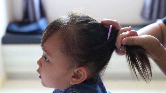 小女孩享受着美发师吹干她的头发