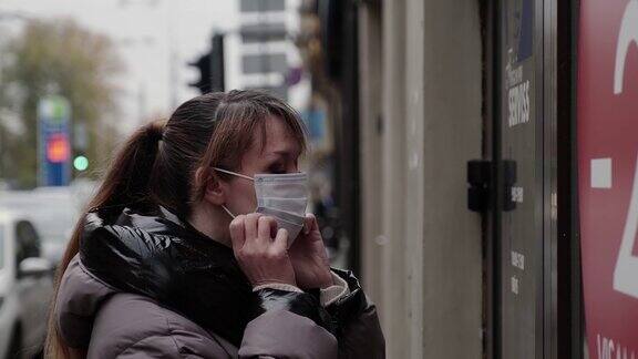一名妇女在进入商店前戴上了防护面具戴口罩对抗Corona病毒