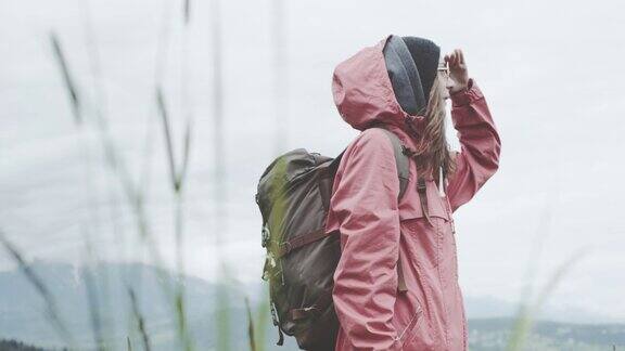 年轻女子环顾草地春天在山