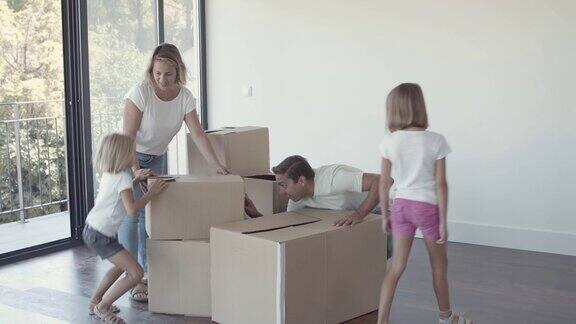 幸福的父母和两个女孩搬进了新公寓