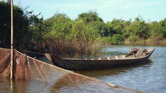 小独木舟系在竹竿上渔网散布在河上