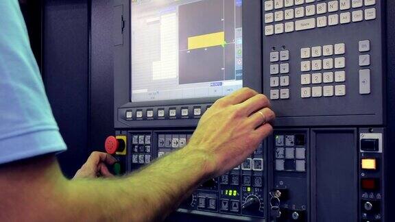 在控制面板上工作的人在工厂里和一台工业机器一起工作