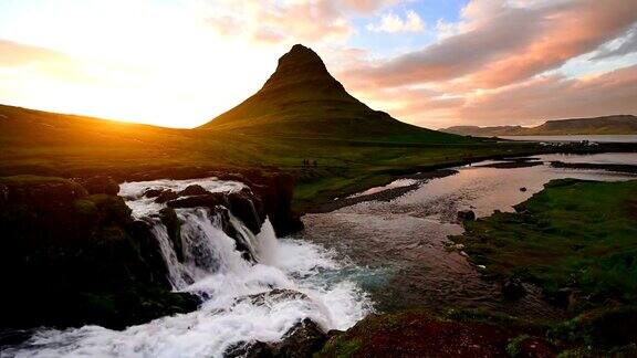 冰岛西部的基尔丘费特尔山瀑布在日落时倾泻而下