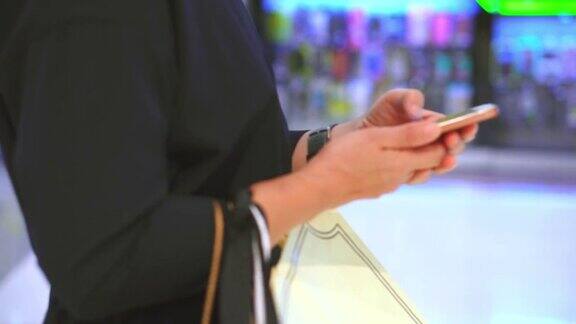 一名女子在购物中心使用智能手机