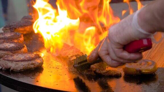 慢镜头:厨师用炽热的火焰在火盆上烤牛排和肉片