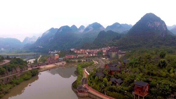 飞越风景如画的村庄在山谷与河流贵州省中国航拍视频
