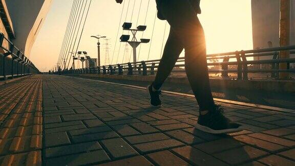 在阳光下的桥上行走的人的腿