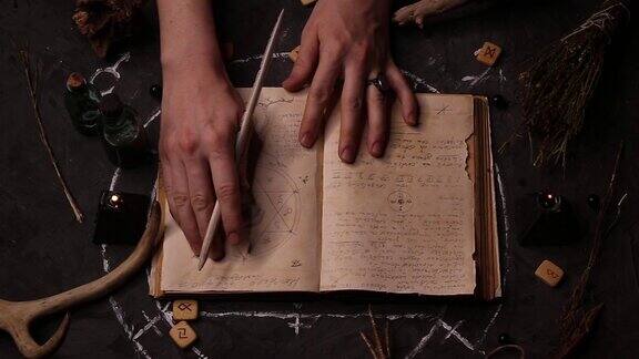 女巫师正在阅读她的手在翻阅古书