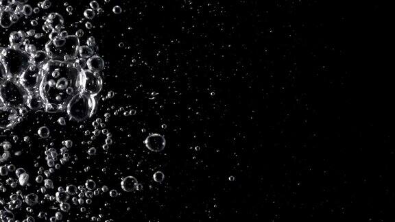 慢动作水气泡从水倒与黑色背景