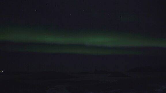 北极光在夜空中群山上空的剪影