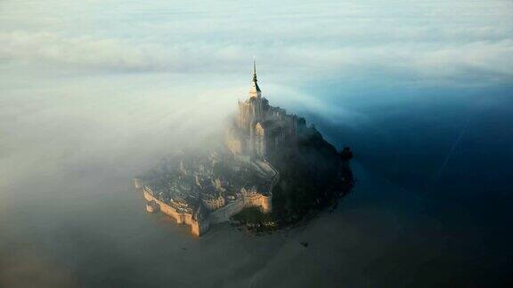 诺曼底的圣米歇尔山岛城堡被令人惊叹的日出雾云所覆盖这是史诗般的航拍