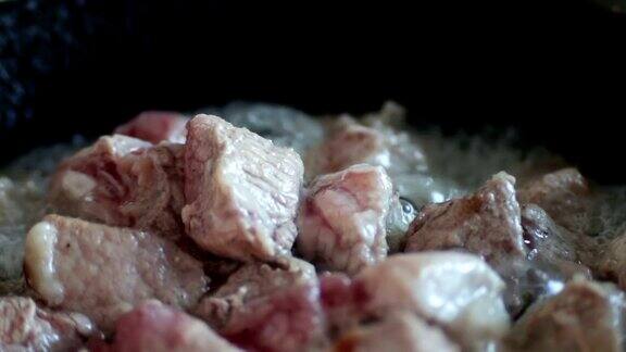 肉在煎锅里煮的慢动作镜头近距离