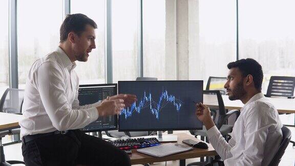 两名多种族投资者经纪人分析在线加密货币股票指数不同的经理、交易员、分析师在办公桌前讨论金融增长市场电脑屏幕上显示图表
