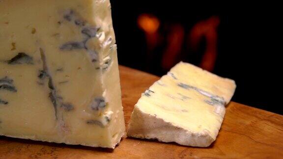 切一块有蓝霉的奶酪掉在一块木板上