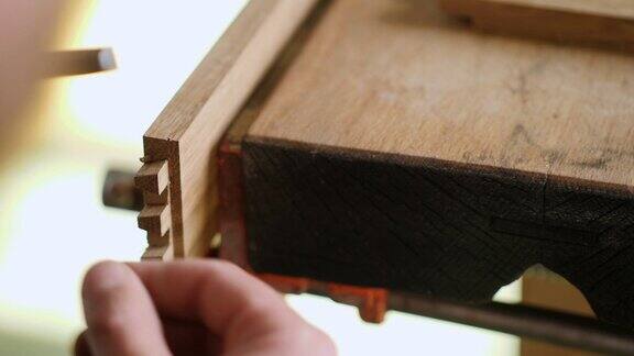 关闭了木工用木凿把燕尾榫刻进橡木板里木工工艺手工艺品木工工具的声音