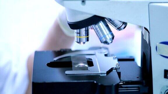 研究人员在实验室使用显微镜慢镜头
